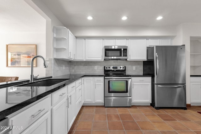 kitchen featuring sink, decorative backsplash, light tile patterned floors, white cabinetry, and stainless steel appliances