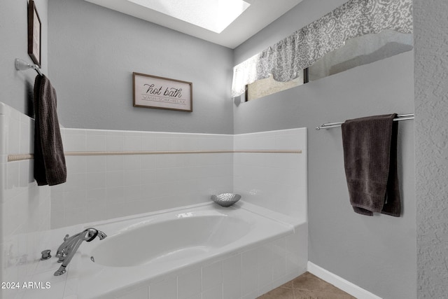 bathroom with tile patterned flooring and a relaxing tiled tub