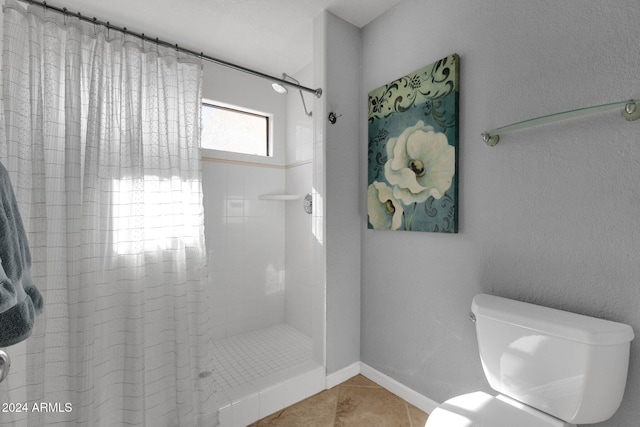 bathroom featuring a tile shower, tile patterned flooring, and toilet