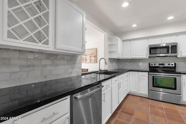 kitchen with appliances with stainless steel finishes, backsplash, white cabinetry, and sink