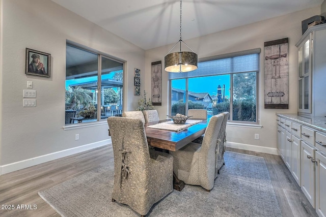 dining space featuring wood finished floors and baseboards