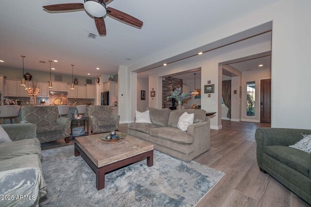 living area featuring visible vents, baseboards, light wood-style flooring, ceiling fan, and recessed lighting