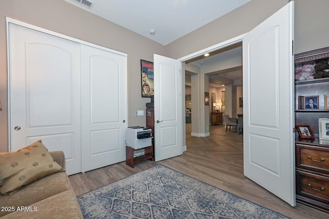 living area featuring visible vents and wood finished floors