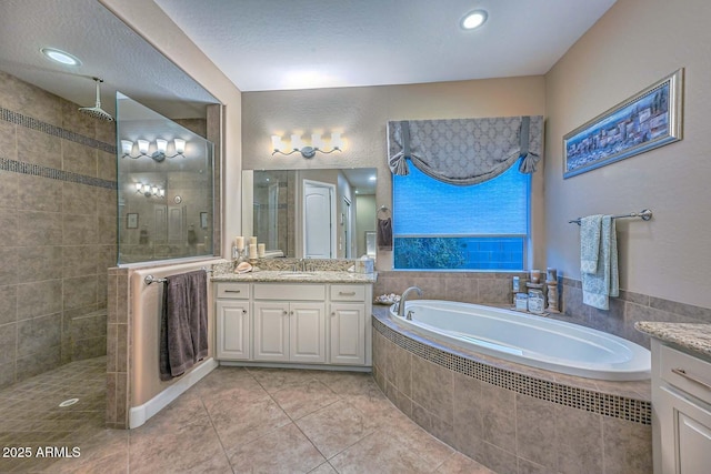 full bath with a bath, tile patterned flooring, tiled shower, and vanity