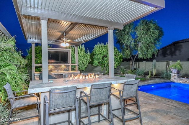 view of swimming pool with a ceiling fan, a fenced in pool, fence, and outdoor dry bar