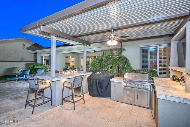 view of patio / terrace with outdoor dry bar, area for grilling, an outdoor kitchen, ceiling fan, and a pergola