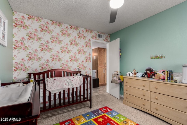 5354 E Ellis St, Mesa, AZ 85205 - carpeted bedroom featuring wallpapered walls, a nursery area, and a textured ceiling