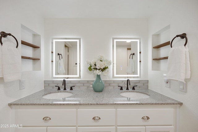 bathroom featuring built in shelves, decorative backsplash, and vanity