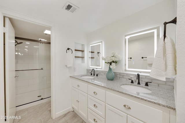 bathroom with tile patterned flooring, vanity, tasteful backsplash, and an enclosed shower