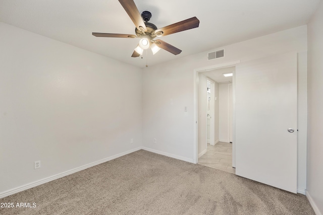 empty room featuring ceiling fan and light carpet