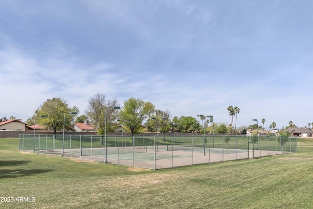 view of tennis court featuring a yard