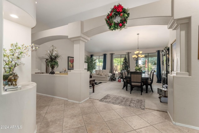 tiled dining room with decorative columns, vaulted ceiling, and a notable chandelier