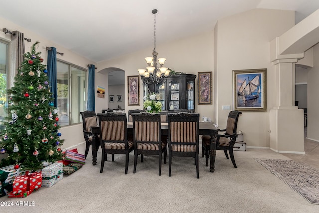 carpeted dining space featuring a chandelier and vaulted ceiling