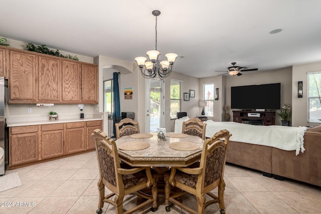 tiled dining space featuring ceiling fan with notable chandelier