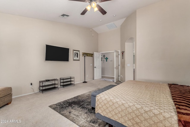 carpeted bedroom with ceiling fan and high vaulted ceiling