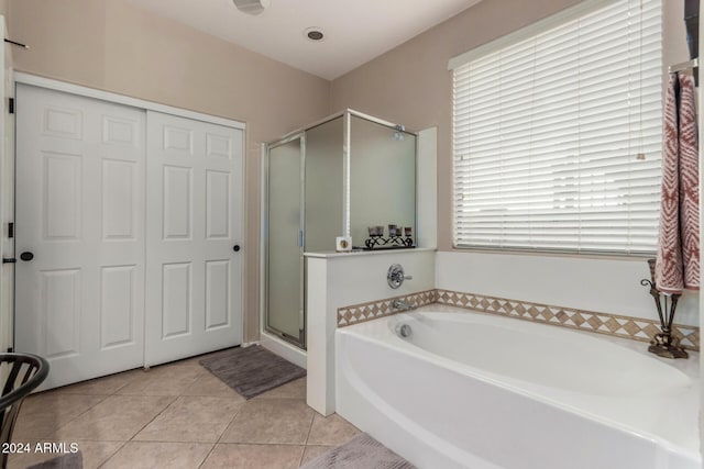 bathroom featuring tile patterned floors, plus walk in shower, and a healthy amount of sunlight