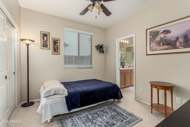 bedroom with light carpet, a closet, ensuite bathroom, and ceiling fan