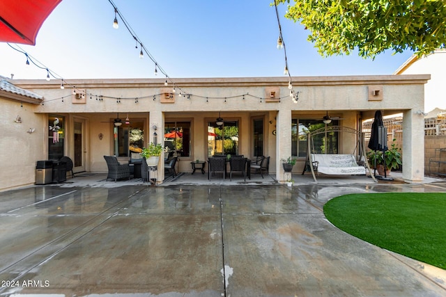 rear view of house with ceiling fan, a patio, and an outdoor living space