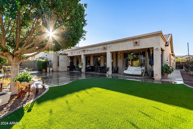 back of property featuring a yard, ceiling fan, and a patio area