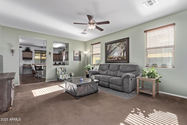 living room featuring dark carpet and ceiling fan