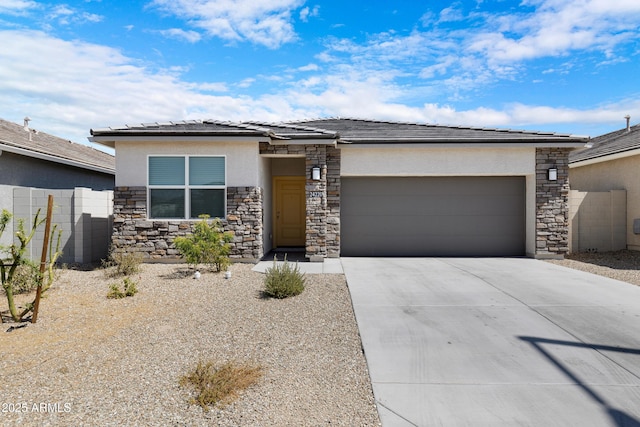 prairie-style house featuring a garage, concrete driveway, fence, and stucco siding