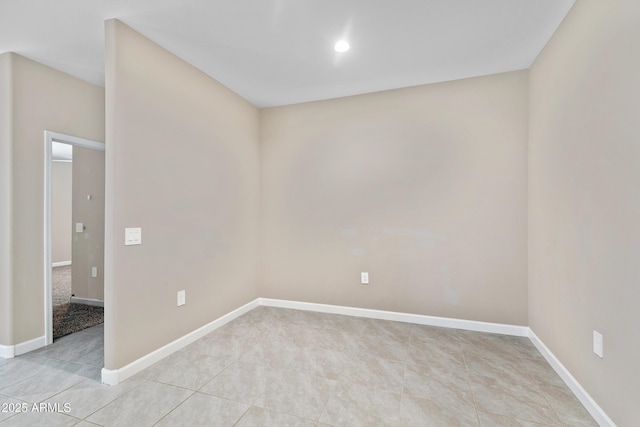 unfurnished room featuring light tile patterned flooring and baseboards