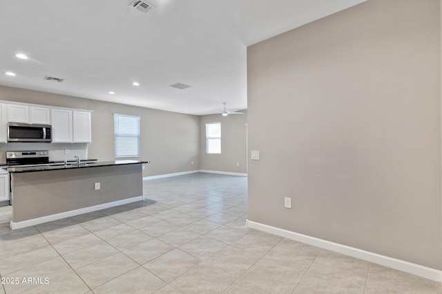 kitchen with ceiling fan, appliances with stainless steel finishes, visible vents, and tasteful backsplash