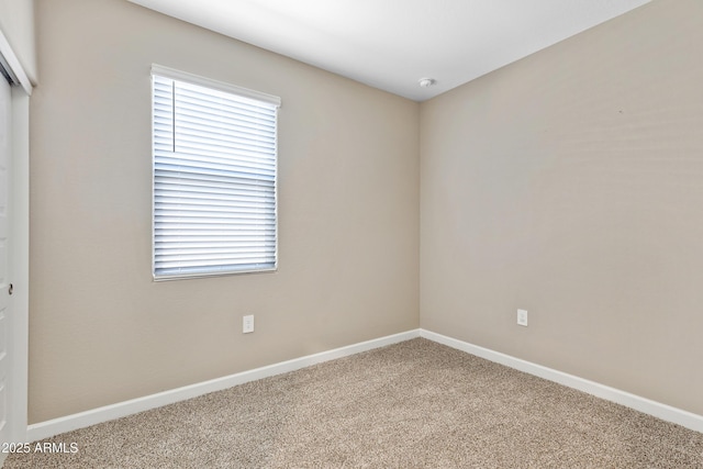 unfurnished room with carpet flooring and baseboards