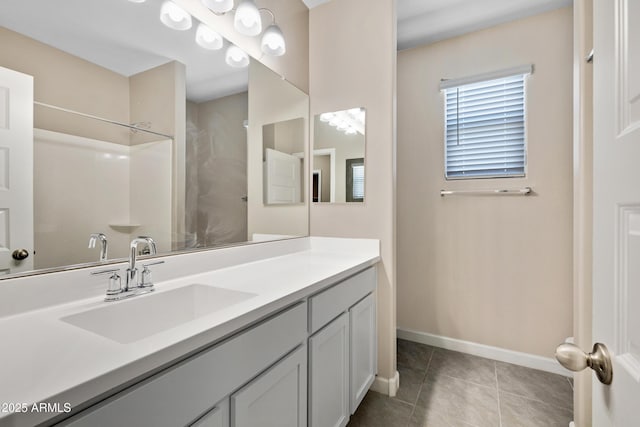 bathroom with walk in shower, tile patterned flooring, vanity, and baseboards