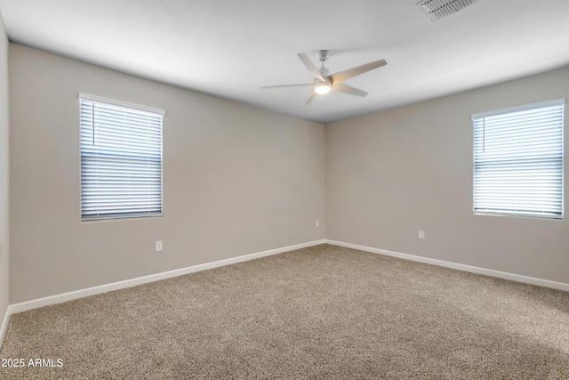 carpeted empty room with a ceiling fan, visible vents, and baseboards