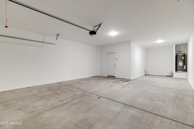 garage featuring baseboards, electric water heater, and a garage door opener