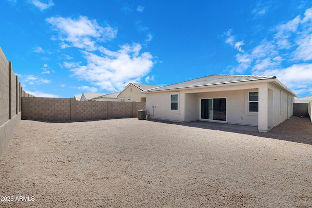 rear view of house with a tile roof, stucco siding, a fenced backyard, and central AC unit