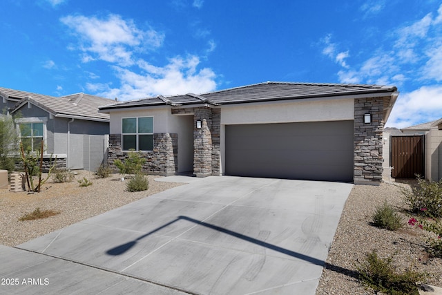 prairie-style house with stucco siding, concrete driveway, fence, a garage, and a tiled roof