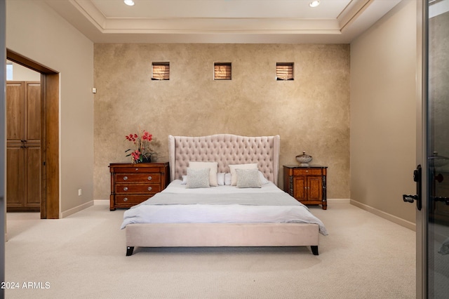 carpeted bedroom featuring a raised ceiling