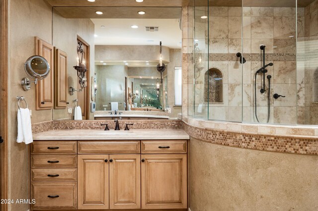 bathroom featuring tiled shower and vanity