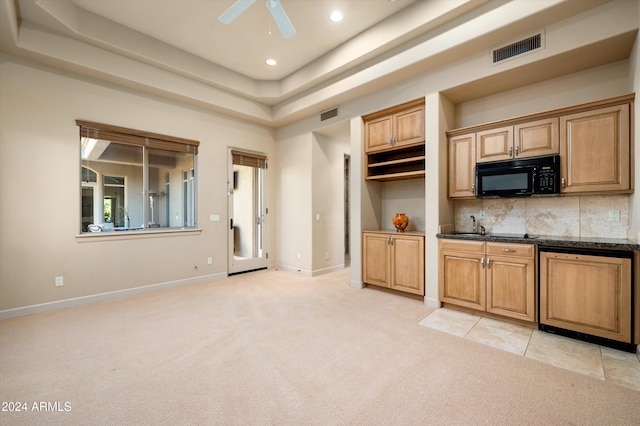 kitchen featuring ceiling fan, light colored carpet, backsplash, and a tray ceiling