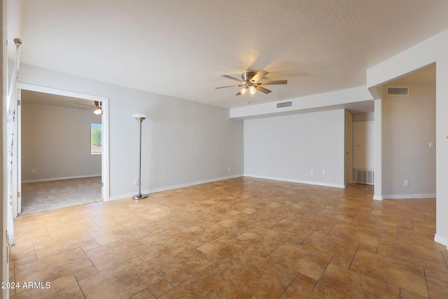 empty room with baseboards, visible vents, and ceiling fan