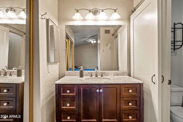 bathroom featuring vanity, toilet, and ceiling fan