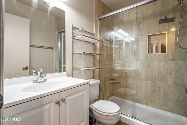 bathroom with toilet, an enclosed shower, and vanity