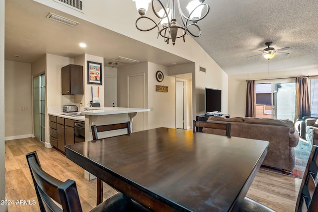 dining area with a textured ceiling, lofted ceiling, light wood-type flooring, and ceiling fan with notable chandelier