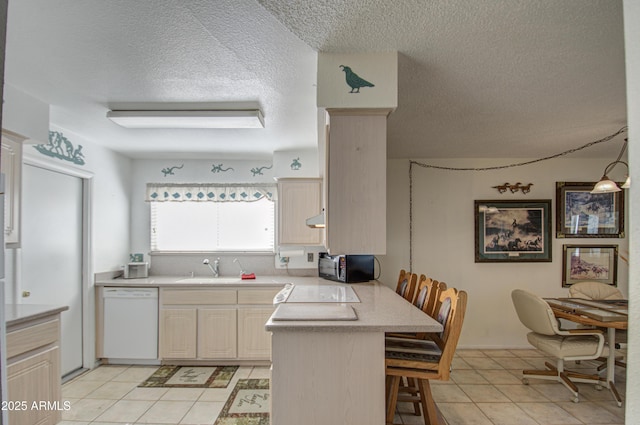 kitchen featuring pendant lighting, sink, a breakfast bar area, white dishwasher, and kitchen peninsula