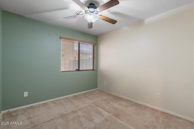 empty room featuring light colored carpet, ceiling fan, and baseboards