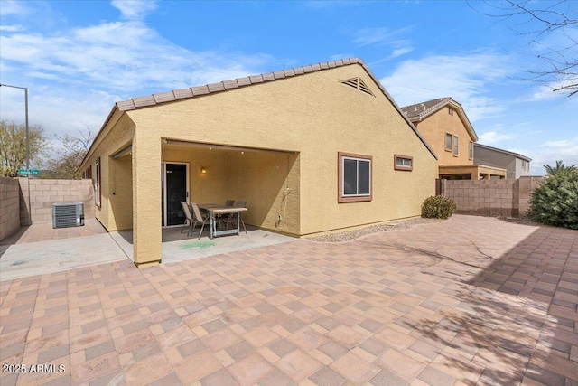 rear view of house featuring a fenced backyard, a patio, and stucco siding