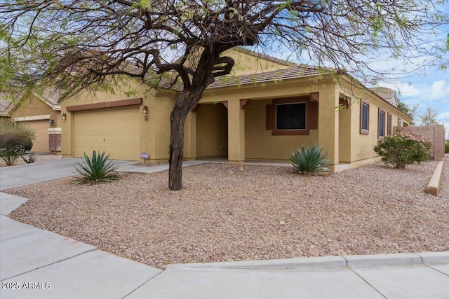 ranch-style house with driveway, an attached garage, and stucco siding