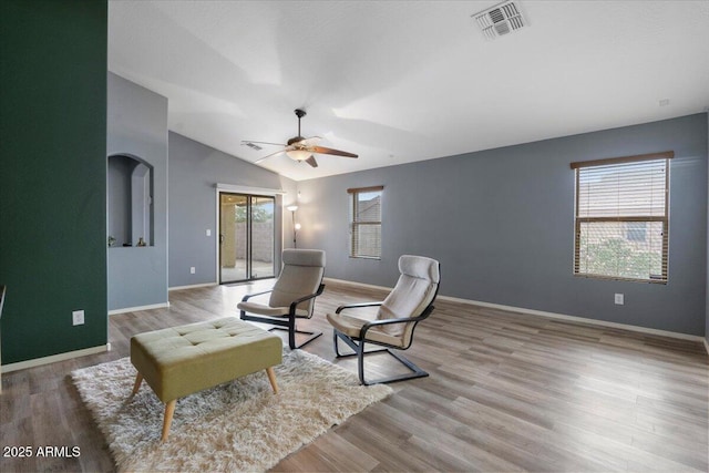 sitting room with baseboards, visible vents, lofted ceiling, ceiling fan, and wood finished floors