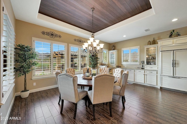 dining area featuring dark wood-style flooring, wooden ceiling, a raised ceiling, and baseboards