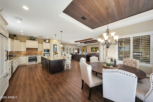 dining room with dark wood-style flooring, a raised ceiling, visible vents, and recessed lighting