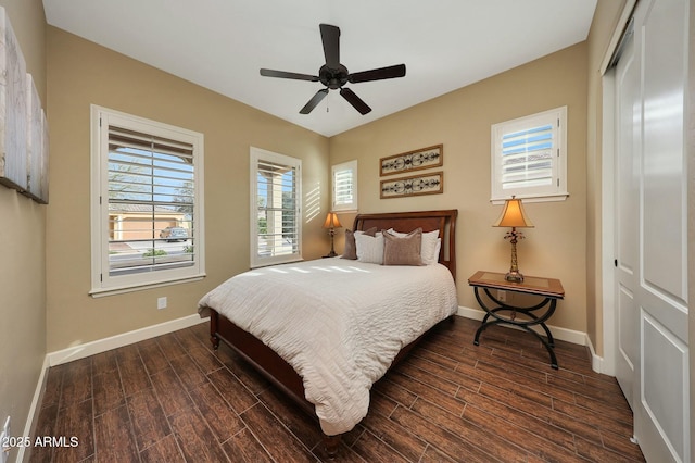 bedroom featuring a ceiling fan, baseboards, dark wood finished floors, and a closet