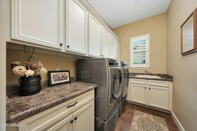 laundry room with washer and dryer, cabinet space, a sink, and wood finish floors