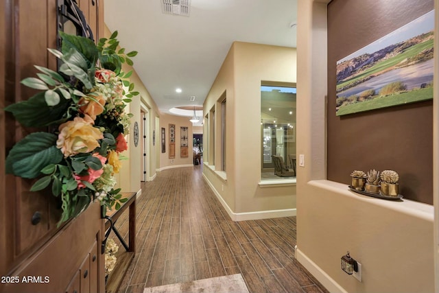 hall with baseboards, visible vents, and wood tiled floor